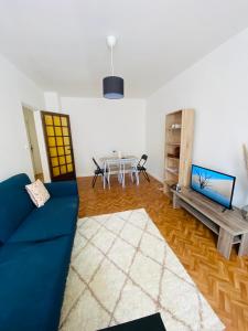 sala de estar con sofá azul y mesa en Chambre Madoumier, en Limoges