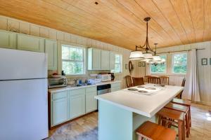 a kitchen with a white refrigerator and wooden ceilings at Pinnacle Mountain Falls Sunset Cottage with Deck in Sunset