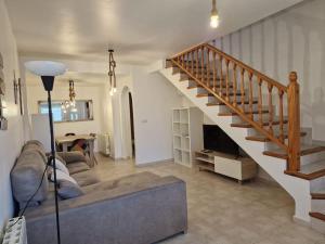 uma sala de estar com um sofá e uma escada em Casa Alanis em Gran Alacant