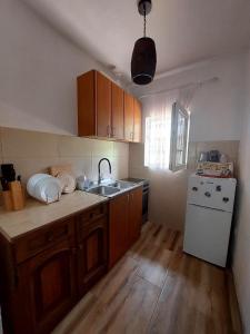 a kitchen with wooden cabinets and a white refrigerator at Vila Paramida in Šavnik