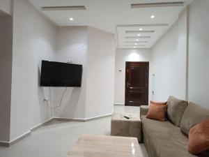 a living room with a couch and a flat screen tv at شقة جميلة وهادئة in Agadir