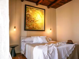 a bedroom with a bed with a painting on the wall at Dimora d'Arte Mariano Pietrini in Barcellona-Pozzo di Gotto