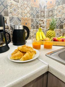 a plate of croissants on a kitchen counter with fruit at Venetian Gem Central Corfu Retreat in Kanoni