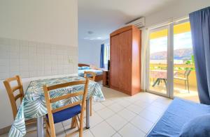 a bedroom with a table and a view of a balcony at Apartments Ada in Baška