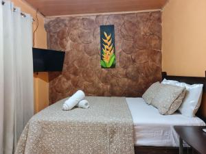 a bedroom with two beds and a stone wall at Cabina Arenal Z13 in Fortuna