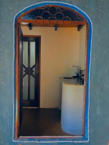 a mirror reflection of a kitchen with a door at Espaço Shanti - Chalés in Sao Jorge