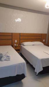 2 camas en una habitación de hotel con 2 camas en Flat Caldas Novas, en Caldas Novas