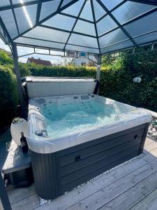 a hot tub under an umbrella on a deck at Ferienwohnung Schlossblick - 4 Sterne Sauna Pool Whirlpool privat in Braunfels