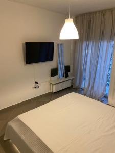 a bedroom with a bed and a flat screen tv at Glyfada apartment near the Center in Athens