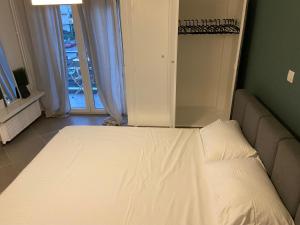 un letto bianco in una stanza con finestra di Glyfada apartment near the Center ad Atene