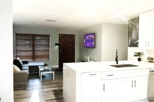 a kitchen with white cabinets and a living room at SUPER CLOSE Beach, Airport, port, Downtown, Wynwood in Miami