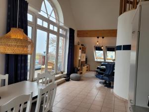 a living room with a table and chairs and a dining room at SUNSET LOFT Rerik Meerblick Maisonettewohnung mit großem Balkon in Rerik