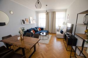 uma sala de estar com um sofá azul e uma mesa em Stilvoller Altbau in zentraler Lage em Dresden