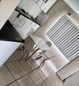 two white chairs and a table in a kitchen at Luca's Place in Durban