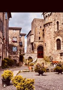 an old stone building with flowers in a courtyard at La casa del Borgo Anagni in Anagni