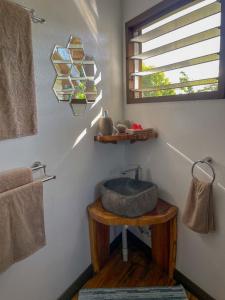 ein Badezimmer mit einem Steinwaschbecken und einem Fenster in der Unterkunft Vakanananu Retreat in Matei