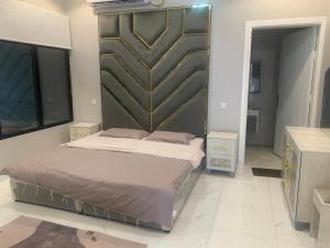 um quarto com uma cama com uma grande cabeceira de cama em شاليهات تركواز em Ash Shuwaybiţ