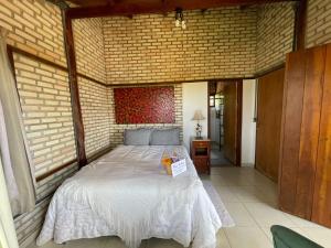 a bedroom with a bed in a brick wall at Guest House Jardim Botânico Brasília in Brasilia