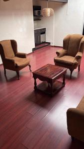 a living room with two chairs and a coffee table at Hotel Rincon Real Suites in Durango