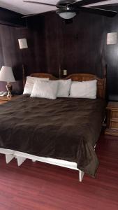 a bedroom with a large bed with a brown blanket at Hotel Rincon Real Suites in Durango