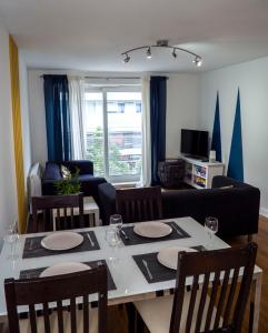 - un salon avec une table, des chaises et un canapé dans l'établissement Stylish 2 bedroom apartment in the heart of Epsom town centre, à Epsom