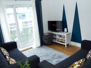 a living room with two couches and a tv at Stylish 2 bedroom apartment in the heart of Epsom town centre in Epsom