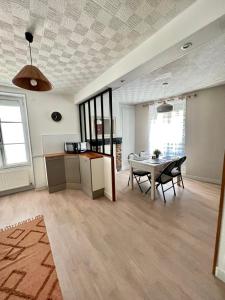 uma sala de estar com uma mesa e uma cozinha em LE PETIT VOLTAIRE - Proche Centre Ville - Spacieux em Châteauroux