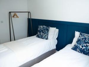 two beds sitting next to each other in a room at Stylish 2 bedroom apartment in the heart of Epsom town centre in Epsom