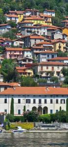 un grupo de edificios en una colina junto al agua en Lora Lake Villa, en Ossuccio