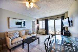 a living room with a couch and a glass table at Inviting Virginia Beach Condo with Community Pool in Virginia Beach