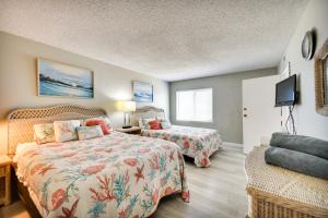 1 dormitorio con 2 camas y TV de pantalla plana en Inviting Virginia Beach Condo with Community Pool en Virginia Beach
