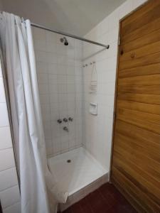 baño con ducha con cortina blanca en Departamento Altos Penitentes Mendoza en Los Penitentes