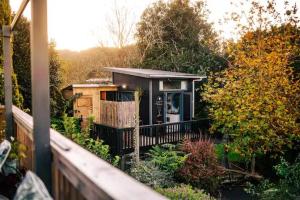 a small house with a fence in a garden at Starry Nights cabin fever in Waikino