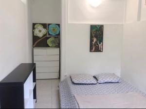 - une petite chambre avec un lit et une commode dans l'établissement Jireh-plénitude, à Fort-de-France