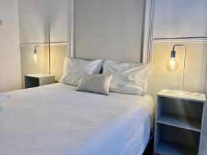 a bedroom with a white bed with two lamps at Lisbon Guests Apartments in Lisbon