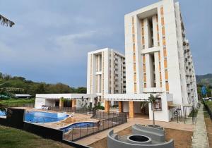 a hotel with a swimming pool in front of a building at APARTAESTUDIO EN VILLETA in Villeta
