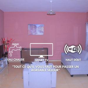 salon z różową ścianą i kanapą w obiekcie Le beau séjour - Maison meublée 3 pièces w mieście Libreville