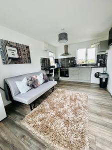 a living room with a couch and a kitchen at Ocean View Apartment - Connemara in Galway