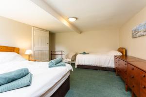 a bedroom with two twin beds and a dresser at Bilton Farm Cottage No2 in Alnmouth