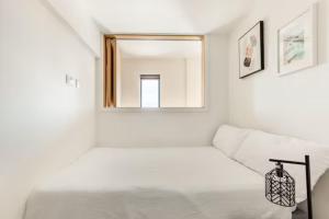 ein weißes Zimmer mit einem Bett und einem Spiegel in der Unterkunft Two Bedrooms Exquisite En-Suite Apartment Deansgate in Manchester