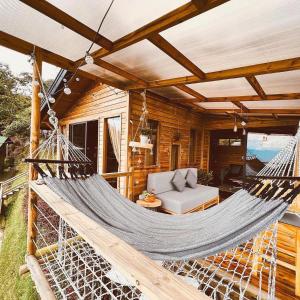 a hammock on a porch of a log cabin at Monte Santa Elena in Medellín