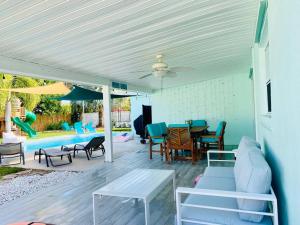 a patio with a table and chairs and a pool at Island Vibes Beach House & 10 min walk to beach in Fort Pierce
