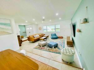 a living room with a couch and a table at Island Vibes Beach House & 10 min walk to beach in Fort Pierce