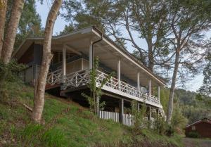 uma casa no topo de uma colina com árvores em Cabaña puerto varas, a orillas del Lago LLanquihue em Puerto Varas