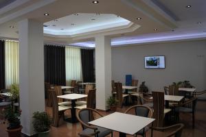 uma sala de jantar com mesas e cadeiras num restaurante em Hotel Mondo em Gjirokastër