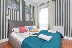 a bedroom with a bed with a table on it at Seaside Sopot Apartment with Parking and Gym by Renters in Sopot
