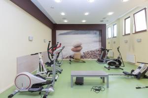 einen Fitnessraum mit Laufbändern und Trainingsgeräten in einem Zimmer in der Unterkunft Seaside Sopot Apartment with Parking and Gym by Renters in Sopot