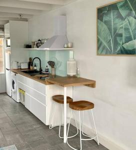 uma cozinha com uma mesa e dois bancos em Oceanic Apartment Sorrento em Sorrento