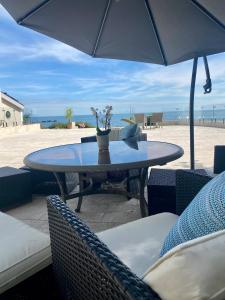 聖布雷拉德的住宿－Portelet Bay，海滩上的桌椅和遮阳伞