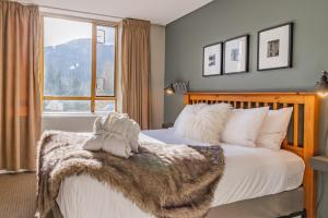 Un dormitorio con una cama con una manta peluda. en Cascade en Whistler